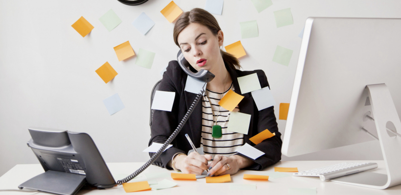 Studio shot of young woman working in office covered with adhesive notes